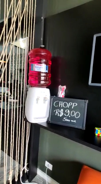 Detalhe do balcão de bebidas da Barbearia Moruk, com espelho e decoração industrial